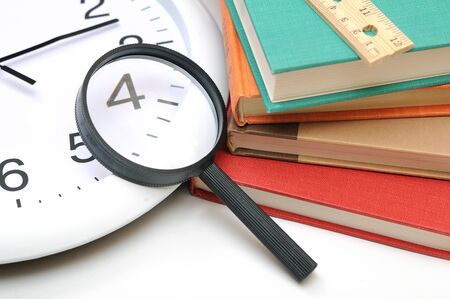graduation concept with  books, magnifying and clock