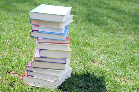 a pile of colorful books on lawn in campusの写真素材