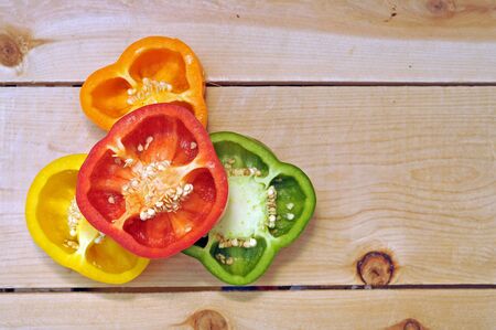 colorful bell peppers on wooden shelfの写真素材