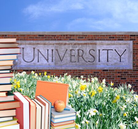 concept of education: books and apple in the front of universityの写真素材