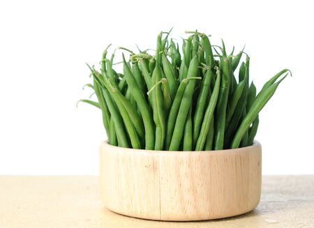green beans in wooden bowl on white backgroundの写真素材