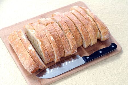 sliced ciabatta flat bread and knife on cutting board