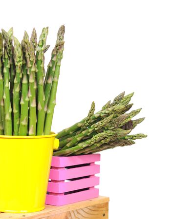 fresh asparagus in yellow pail on white at market placeの写真素材