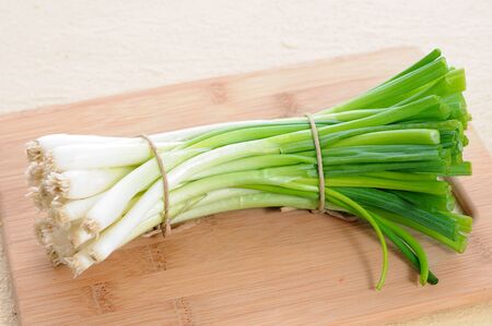 a bunch green onion  on cutting board の写真素材