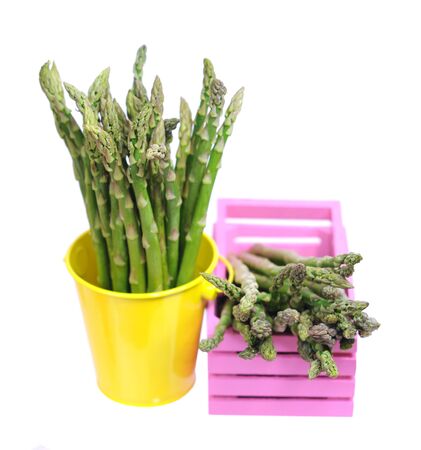 fresh asparagus in pink bucket isolated on whiteの写真素材