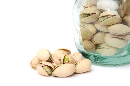 a group of pistachio in jar on white の写真素材