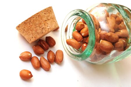 peanuts in glass jar on white background 