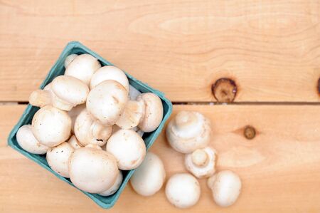 white mushroom in basket on wooden tableの写真素材