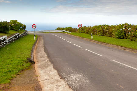 Empty road to the ocean with two signs, San Miguel, Azores, Portugalの写真素材