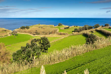 View to the green field, town and mountains at the Atlantic ocean coast, San Miguel, Azores, Portugalの写真素材