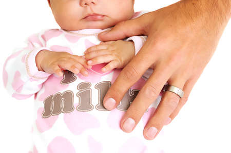 father placing hand on new baby girl with wedding ring visibleの写真素材