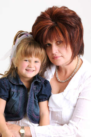 young daughter kissing mother on the cheek and smilingの写真素材