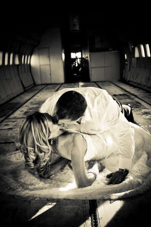 sexy young  adult wedding couple laying in the fuselage of airplaneの写真素材