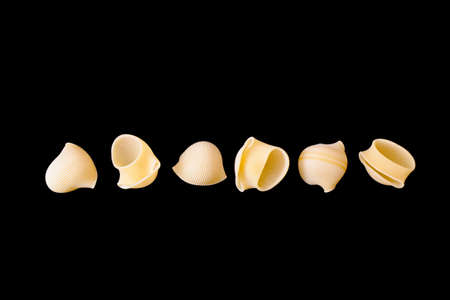 Six items of rigate pasta isolated on black backgroundの写真素材