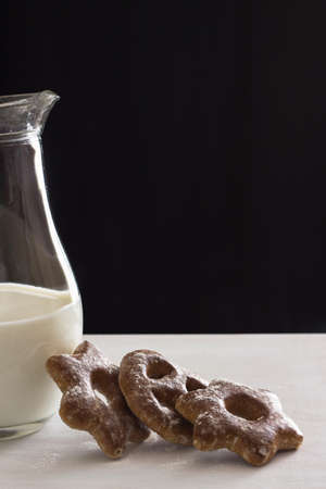 Bavarian cookies iced with sugar powder with a jug of milkの写真素材