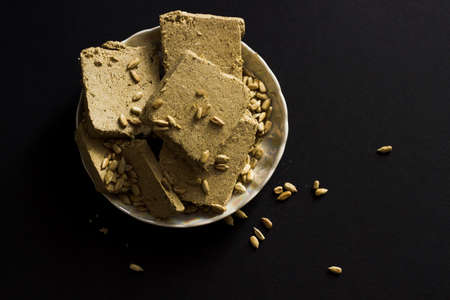 Sunflower halva with seeds on plate on black backgroundの写真素材