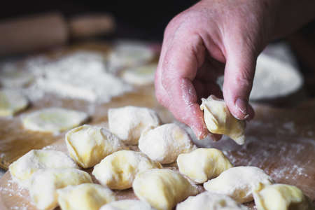 Old woman cooking Ukrainian traditional dumplings with cottage cheeseの写真素材