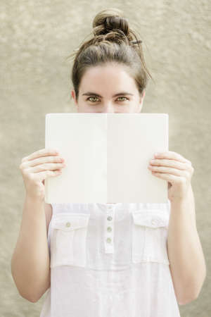 Close up Woman with green eyes wearing white sleeveless blouse and pencil in her hair smiling and...