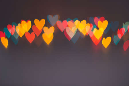 Line of colorful blurred heart shape lights on grey backgroundの写真素材