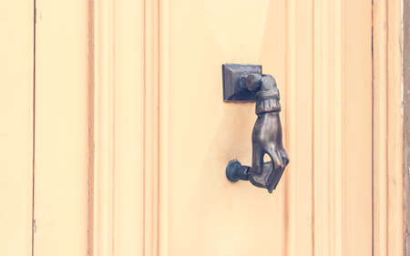Hand shaped Metal Knocker on Beige Wooden door, Maltaの写真素材