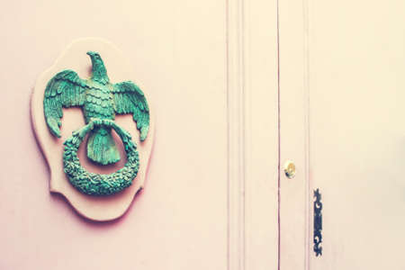 A Pair of Old Metal Empire Style Eagle Knockers on Wooden Pink Door in Mdina, Malta. Space for your textの写真素材