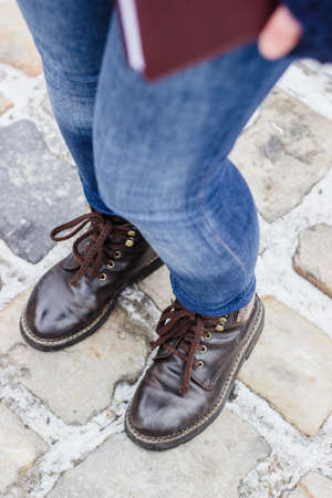 High angle view on woman's legs wearing brown shoes and blue jeansの写真素材