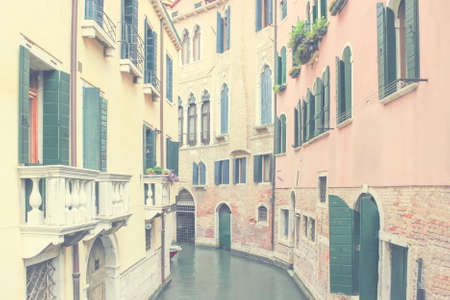 Background with old medieval houses along canal of Venice, Italyの写真素材