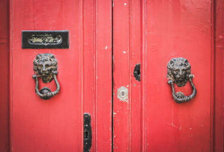Old Red Wooden Doors with a Pair of Lion Head Metal Knockers in Mdina, Maltaの写真素材