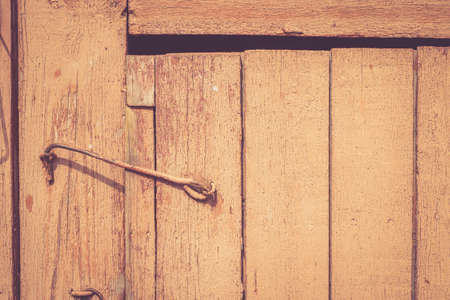 Old rustic wooden door locked with hookの写真素材
