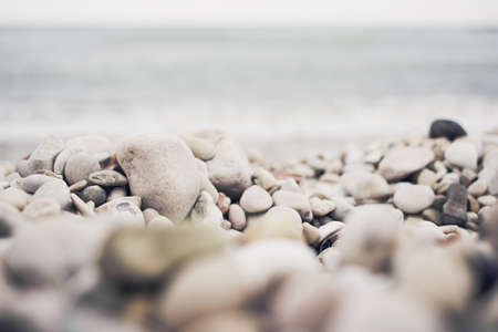 Pebble beach of the Adriatic Sea. Stack of rocks with water on the background. Selective focusの写真素材