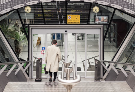 BRUSSELS, BELGIUM - AUGUST 21, 2014: Man going down the stairs to Gare de Bruxelles-Luxembourg train station at the Espace Leopold (Leopold Square) under the Esplanade of the European Parliamentのeditorial素材