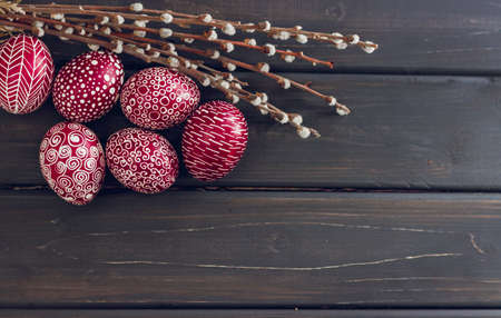 Still life with Pysanka, decorated Easter eggs, dry willow branches on black wooden background, top view, copy spaceの写真素材