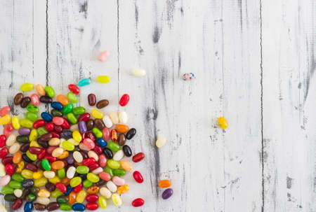 Candy jelly beans of different colors on bright whitewashed wooden background. Space for your textの写真素材