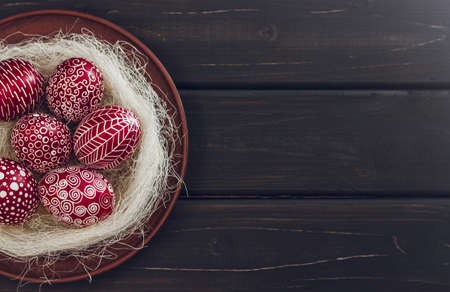 Still life with Pysanka, decorated Easter eggs, dry willow branches on black wooden background, top view, copy spaceの写真素材