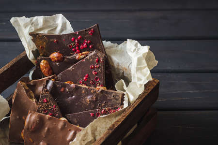 Variety of chocolate bars in wooden box over dark wooden backgroundの写真素材