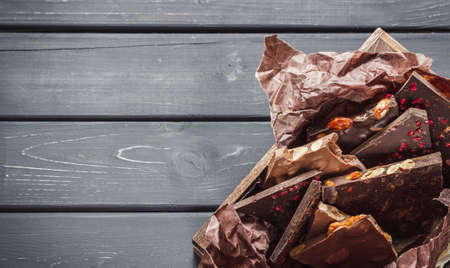 Variety of chocolate bars in wooden box over dark wooden backgroundの写真素材