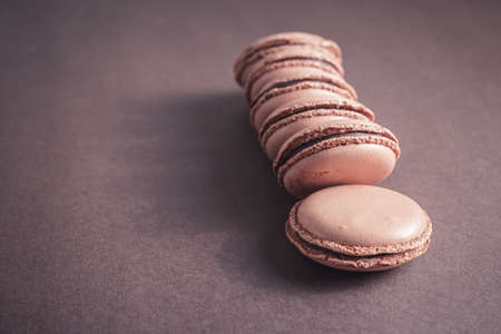 Row of Chocolate pastel brown Macarons or Macaroons over dark backgroundの写真素材