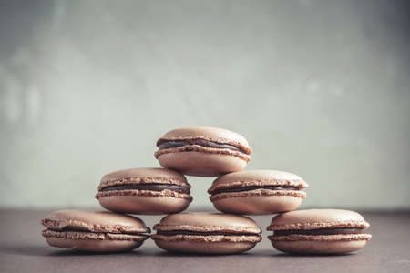 Pyramid of Chocolate pastel brown Macarons or Macaroons over stone backgroundの写真素材
