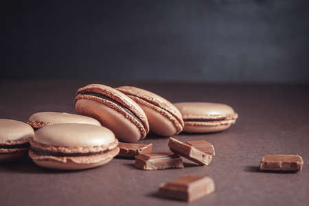 Stack of Chocolate pastel brown Macarons or Macaroons over dark backgroundの写真素材