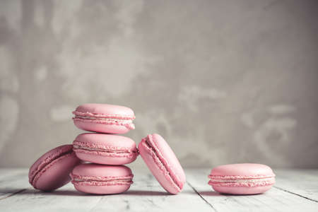 Stack of Raspberry pastel pink Macarons or Macaroons over grey concrete wall backgroundの写真素材