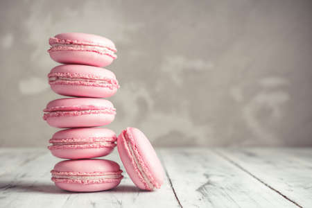 Stack of Raspberry pastel pink Macarons or Macaroons over grey concrete wall backgroundの写真素材