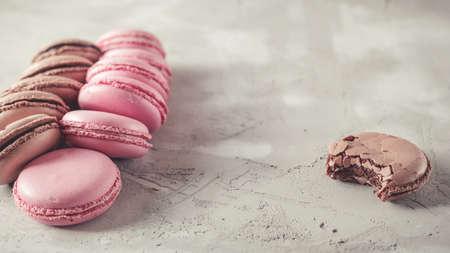 Raspberry and Chocolate pastel colored Macarons or Macaroons over concrete backgroundの写真素材