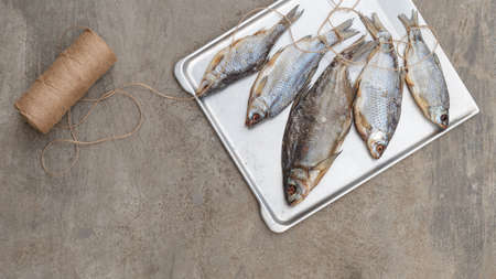 Taranka, Sun Dried Salty River Fish, Classic Beer Snack in Post Soviet Countries. Top view, grey concrete backgroundの写真素材