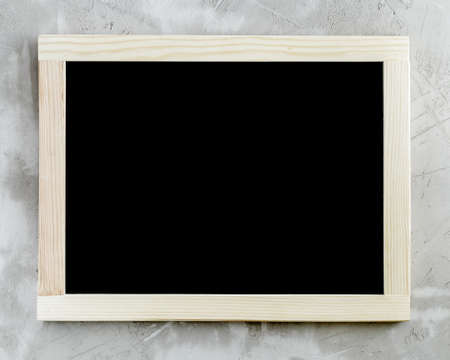 Blank black chalkboard with wooden frame on concrete background.の写真素材