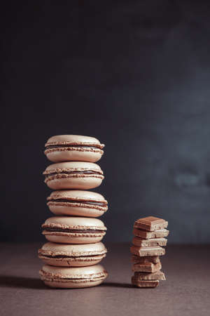 Stack of Chocolate pastel brown Macarons or Macaroons over dark backgroundの写真素材