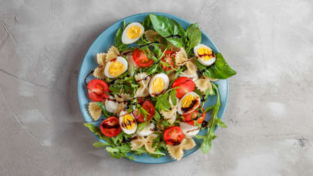 Pasta salad with quail eggs, tomatoes, rucola, mozzarella and basilの写真素材