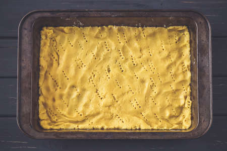 Raw dough for pie in baking pan prepared to put filling in. Baking concept, making pie processの写真素材