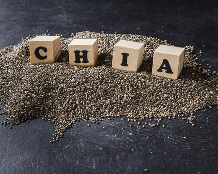 Heap of healthy organic chia seeds rich in omega-3 fatty acids over dark backgroundの写真素材