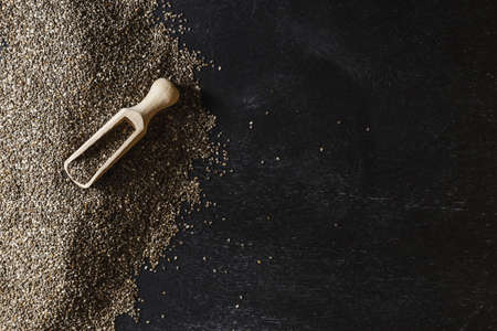 Heap of healthy organic chia seeds rich in omega-3 fatty acids over dark backgroundの写真素材
