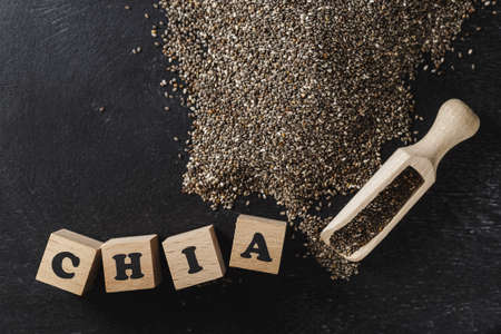 Heap of healthy organic chia seeds rich in omega-3 fatty acids over dark backgroundの写真素材
